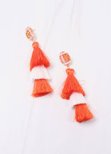 Load image into Gallery viewer, Two orange and white tassle earrings. Each is set with a glittered football post and then an orange tassle, a white tassle, and one final orange tassle.  These earrings are super cute for football and game days.